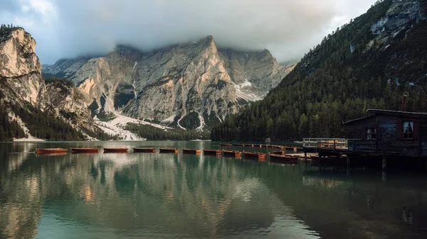 Bela paisagem de Braies Lago di Braies lugar romântico com ponte de madeira e barcos no lago alpino, Alpes Montanhas, Dolomitas, Itália, Europa — Fotografia de Stock