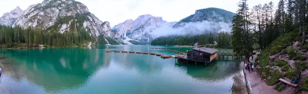 ภูมิทัศน์ที่สวยงามของ Braies Lake Lago di Braies สถานที่โรแมนติกที่มีสะพานไม้และเรือบนทะเลสาบแอลป์เทือกเขาแอลป์ Dolomites, อิตาลี, ยุโรป — ภาพถ่ายสต็อก