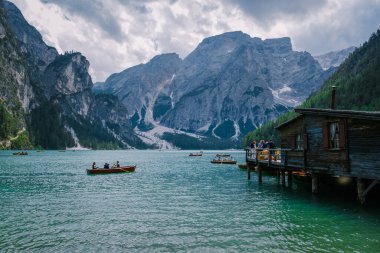 Braies Gölü 'nün güzel manzarası Lago di Braies romantik yeri ahşap köprü ve Alp Dağları, Dolomitler, İtalya, Avrupa' da tekneler