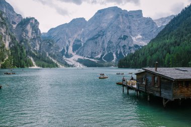 Braies Gölü 'nün güzel manzarası Lago di Braies romantik yeri ahşap köprü ve Alp Dağları, Dolomitler, İtalya, Avrupa' da tekneler