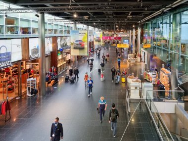Amsterdam Schiphol Havaalanı Hollanda Eylül 2021, Covid19 pandemik korona virüsü sırasında ağızları korunan terminaldeki yolcular