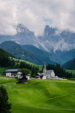 Val di Funes 'deki Santa Magdalena köyü İtalyan Dolomitleri üzerinde. Arka planında renkli ağaçlar ve Odle Dağı grubu olan vadinin sonbahar manzarası. İtalya