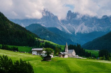 Val di Funes 'deki Santa Magdalena köyü İtalyan Dolomitleri üzerinde. Arka planında renkli ağaçlar ve Odle Dağı grubu olan vadinin sonbahar manzarası. İtalya