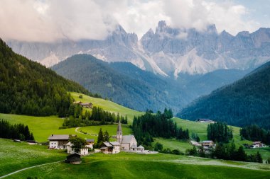 Val di Funes 'deki Santa Magdalena köyü İtalyan Dolomitleri üzerinde. Arka planında renkli ağaçlar ve Odle Dağı grubu olan vadinin sonbahar manzarası. İtalya