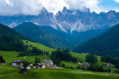 Val di Funes 'deki Santa Magdalena köyü İtalyan Dolomitleri üzerinde. Arka planında renkli ağaçlar ve Odle Dağı grubu olan vadinin sonbahar manzarası. İtalya