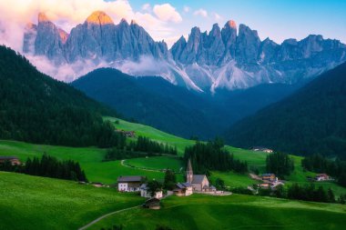Val di Funes 'deki Santa Magdalena köyü İtalyan Dolomitleri üzerinde. Arka planında renkli ağaçlar ve Odle Dağı grubu olan vadinin sonbahar manzarası. İtalya