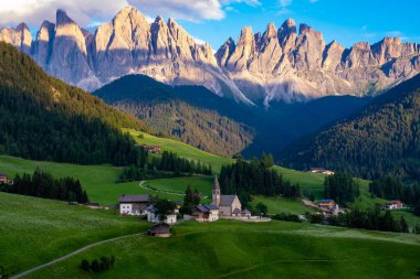 Val di Funes 'deki Santa Magdalena köyü İtalyan Dolomitleri üzerinde. Arka planında renkli ağaçlar ve Odle Dağı grubu olan vadinin sonbahar manzarası. İtalya