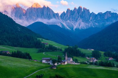 Val di Funes 'deki Santa Magdalena köyü İtalyan Dolomitleri üzerinde. Arka planında renkli ağaçlar ve Odle Dağı grubu olan vadinin sonbahar manzarası. İtalya