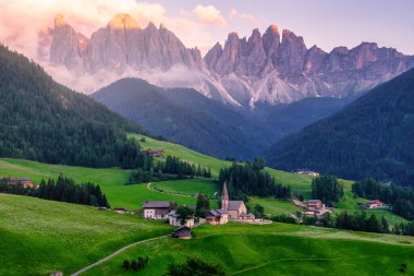 Val di Funes 'deki Santa Magdalena köyü İtalyan Dolomitleri üzerinde. Arka planında renkli ağaçlar ve Odle Dağı grubu olan vadinin sonbahar manzarası. İtalya