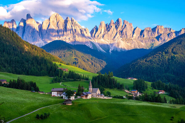 Santa Magdalena village in Val di Funes on the italian Dolomites. Autumnal view of the valley with colorful trees and Odle mountain group on the background. Italy