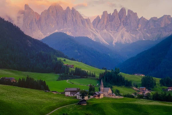 イタリアのドロミテのヴァル・ディ・フネスにあるサンタ・マグダレナ村。背景にカラフルな木々やOdle山のグループと渓谷の秋の景色。イタリア — ストック写真