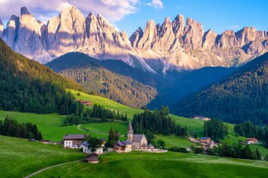 Val di Funes 'deki Santa Magdalena köyü İtalyan Dolomitleri üzerinde. Arka planında renkli ağaçlar ve Odle Dağı grubu olan vadinin sonbahar manzarası. İtalya