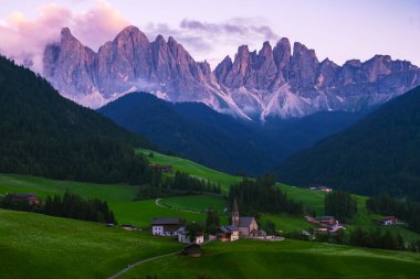 Val di Funes 'deki Santa Magdalena köyü İtalyan Dolomitleri üzerinde. Arka planında renkli ağaçlar ve Odle Dağı grubu olan vadinin sonbahar manzarası. İtalya