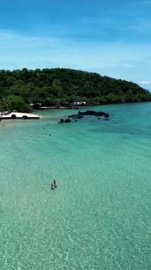 Experience the serene landscape of Koh Kham Island in Thailand, featuring crystal-clear waters and vibrant greenery. Sun-kissed beaches invite relaxation and adventure amidst stunning nature.