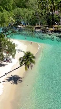 Swim in the clear turquoise waters of Koh Kood, Thailand. Enjoy sunbathing on soft white sands, surrounded by lush greenery. Experience a secluded paradise perfect for relaxation and exploration.
