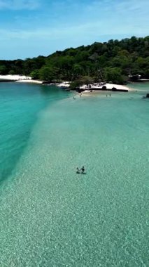 Explore the breathtaking beauty of Koh Kham, Thailand, known for its crystal-clear waters and soft sandy beaches. Visitors enjoy swimming and sunbathing in this tropical paradise.
