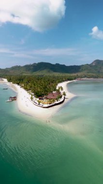 Tayland 'da Koh Mook' un sakin plajlarını keşfedin, yumuşak beyaz kumlar ve bereketli tropikal palmiye ağaçları. Gündüz rahatlamak, yüzmek ya da nefes kesici manzaralardan zevk almak için idealdir..