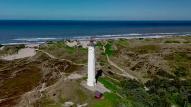 Hava manzaralı Lyngvig Deniz Feneri, Danimarka 'nın sakin kıyı şeridine karşı dimdik ayakta duruyor. Kumlu kumullar ve kıyı suları, doğa aşıkları için mükemmel, pitoresk bir manzara yaratır..