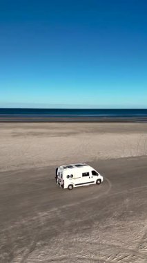 Lakolk Strand, Romo Adası, Danimarka 'nın kumlu kıyılarında giden bir karavan. Güzel sahil, berrak mavi bir gökyüzünün altında uzanır. Rahatlamak için mükemmel bir yer..