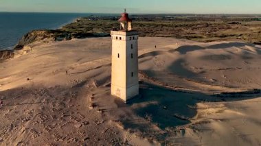 Danimarka kıyı şeridinin dramatik kumullarına karşı dimdik duran nefes kesici Rubjerg Knude Deniz Feneri 'ne tanık olun. Bu ikonik simge deniz ve doğanın büyüleyici görüntülerini sunuyor..