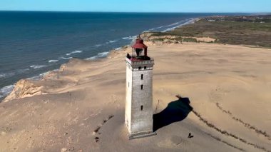 Rubjerg Knude deniz fenerinin büyüleyici güzelliğini tecrübe edin. Danimarka 'nın kumlu sahillerinde görkemli bir şekilde duruyor. Çarpıcı kule Kuzey Denizi 'ne bakıyor ve nefes kesici manzaralar sunuyor..