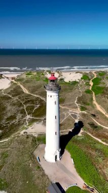 İkonik Lyngvig Deniz fenerini keşfedin, parlak mavi gökyüzüne ve sahil şeridine karşı dimdik ayakta durun. Yeşillik ve kumullar cazibesini arttırarak ziyaretçileri manzaranın tadını çıkarmaya davet ediyor..