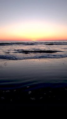 Lakolk Strand, Romo 'da sakin bir gün batımı, yumuşak dalgaların yavaşça kıyıya vurduğu yer. Gündüzün geceye dönüşmesi gibi gökyüzü de güzel bir eğim çiziyor. Huzurlu yansımalar için mükemmel.