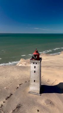 Rubjerknudde deniz feneri gururla durur Danimarka 'nın kumlu sahillerinde, sakin sular ve altın kumlarla çevrili..