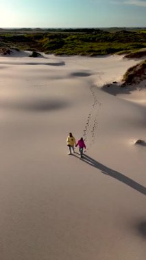 Danimarka 'daki Rabjerg Mile' ın yumuşak kum tepelerinde berrak mavi bir gökyüzünün altında birkaç gezinti. Manzaranın sakinliği, açık hava aşıkları için mükemmel sakin bir atmosfer yaratır..