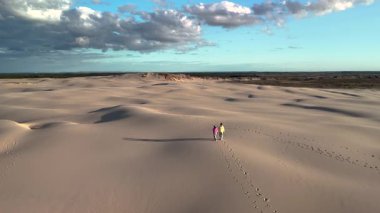 Danimarka 'daki Rabjerg Mile' ın muhteşem kum tepelerinde iki kişi yürüyor. Güzel ve açık bir gökyüzü ile çevrili. Huzurlu manzara benzersiz bir doğal kaçış sunuyor..