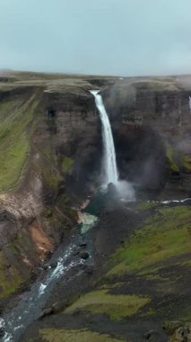 İzlanda 'nın en yüksek şelalelerinden biri olan Haifoss şelalesinde görkemli bir şekilde yemyeşil sularla çevrili kayalık bir kanyona dalıyor..