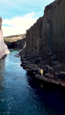 İzlanda 'daki Studlagil Kanyonu' nun çarpıcı güzelliğini keşfedin. Eşsiz bazalt sütunlar ve kristal berraklığında bir nehir macera ve keşif için mükemmel bir doğal ortam yaratır..