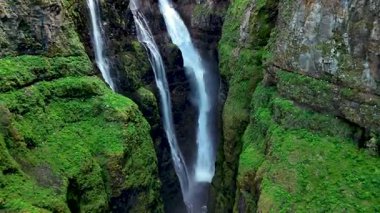 İzlanda manzaralı yeşil uçurumlarda çağlayan, nefes kesici Glimur Şelalesini deneyimleyin..