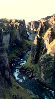 İzlanda 'daki Fjadrargljufur kanyonunun nefes kesici güzelliğini deneyimleyin. Yeşilliğin yükselen kaya oluşumlarıyla buluştuğu yer. Işıldayan sular bu çarpıcı arazide akıyor..