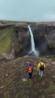 İzlanda 'daki engebeli kayalıklardan dökülen çarpıcı Haifoss şelalesine tanık olun. Maceracılar huşu içinde bu görkemli yeşilliğin ortasındaki doğal güzelliğin tadını çıkarıyorlar..