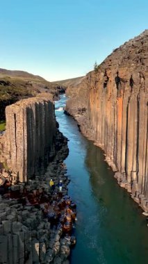 İzlanda 'daki Studlagil Kanyonu' nun nefes kesici güzelliğini keşfedin. Yüksek bazalt sütunlarıyla ve içinden akan huzurlu nehirle karakterize edilmiş..