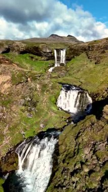İzlanda 'daki Grundarfoss şelalesinin dingin güzelliğini deneyin. Şelalenin çağlayan suları parlak mavi bir gökyüzünün altında yosun kaplı kayaların üzerinden akıyor. Doğa aşıkları ve fotoğrafçılar için mükemmel bir yer..