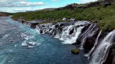 Hraunfossar şelalesi karanlık lav kayalarının üzerinden kristal berrak bir nehre akan büyüleyici çağlayanları içerir. Yeşilliklerle çevrili bu büyüleyici yer İzlanda 'da huzurlu bir kaçış sunuyor..