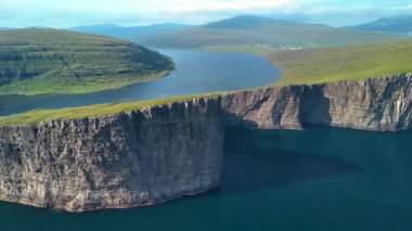 Sorvagsvatn Gölü 'nün nefes kesici manzarası dramatik uçurumlarını ve yemyeşil bahçelerini gözler önüne seriyor. Aydınlık bir günde yakalanan Faroe Adaları 'nın sükuneti....