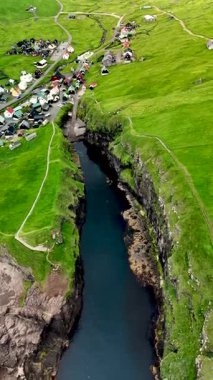 Bereketli yeşil tepelerin arasından sakin bir nehrin estiği Faroe Adaları 'nın çarpıcı manzarasını keşfedin. Gjogv köyü