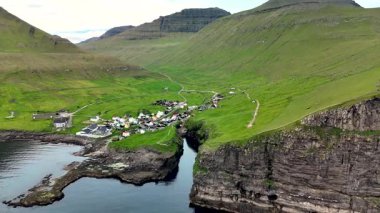 Gjogv Faroe Adaları 'nın büyüleyici güzelliğini keşfedin, yemyeşil tepeler, dramatik uçurumlar ve sahil kenarındaki sakin bir köy. Nefes kesici manzaralar arayan doğa meraklıları için idealdir..