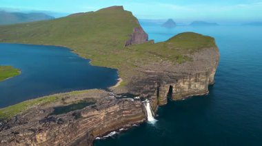 Uçurumların canlı mavi sularla buluştuğu Faroe Adaları 'ndaki Sorvagsvatn Gölü' nün çarpıcı manzarasını keşfedin. Bu mekan, açık gökyüzünün altındaki dramatik tepeleri ve uzak adaları gösteriyor..