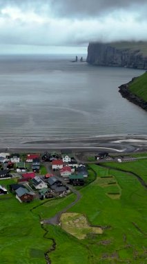 Faroe Adaları 'nda renkli evlerin engebeli kıyı şeridi ile buluştuğu çarpıcı bir köy olan Tjornuvik' i keşfedin. Yükselen kayalıklar ve dingin sular resimli bir manzara yaratır..