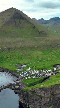 Yüksek uçurumlar ve yemyeşil alanlar arasında kurulmuş Gjogv köyünü gösteren Faroe Adaları 'nın çarpıcı manzarasını deneyin. Doğa meraklıları ve gezginleri için ideal..