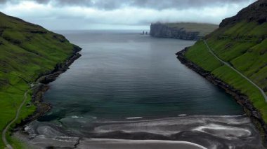 Faroe Adaları 'ndaki sakin suların üzerinde görkemli uçurumlar yükselir. Bereketli yeşil tepeler sakin körfezi çerçevelerken, dramatik kıyı şeridi doğa güzelliklerinde keşif ve maceraya davet ediyor. Tjornuvik