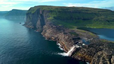 Uçurumların okyanusla buluştuğu Sorvagsvatn Gölü 'nün nefes kesici güzelliğini keşfedin. Canlı yeşiller ve dramatik kaya oluşumları unutulmaz bir doğa harikası yaratır..