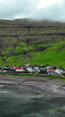 Faroe Adaları 'ndaki görkemli yeşil tepelerin altında bulunan büyüleyici Tjornuvik köyünü keşfedin..