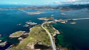 Norveç 'teki dolambaçlı Atlantik Okyanus Yolu' nu yakalayan nefes kesici hava manzaraları kayalık kıyı şeritlerini, turkuaz suları ve berrak mavi gökyüzü altında yemyeşil suları gözler önüne seriyor..