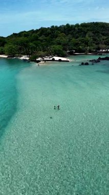 Tayland 'daki Koh Kham Adası' nın güzelliğini, berrak suları ve yemyeşil sularıyla tecrübe edin. Ziyaretçiler, bu tropikal cennette sakin bir dinlenme ve keşif gününün tadını çıkarabilirler..