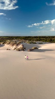 Danimarka 'daki Rabjerg Mil' in dingin güzelliğini deneyimleyin. Dostlar, canlı bir gökyüzü altında, geniş kum tepelerinde yürürken doğanın ve maceranın özünü yakalıyorlar..